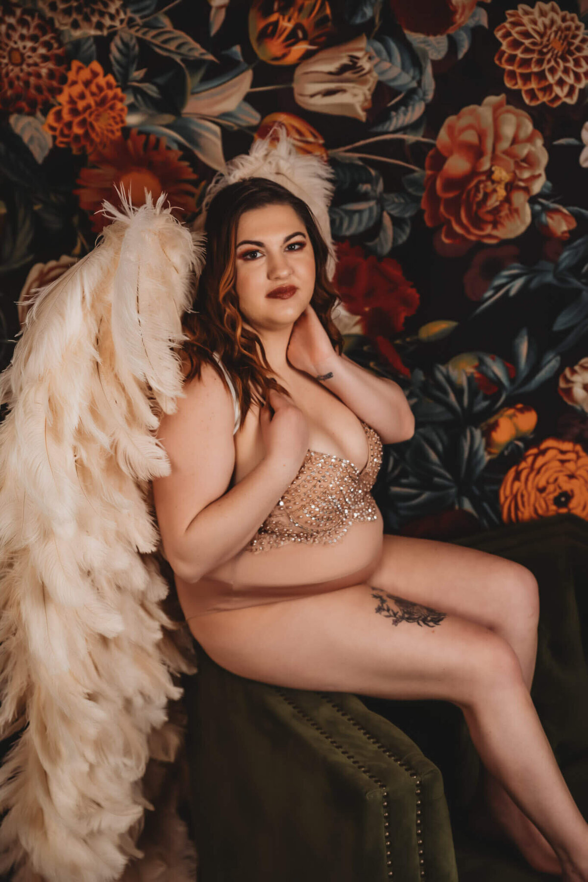 beautiful plus size woman wearing nude lingerie with sparkles, wearing cream colored angel wings, soft smiling at the camera