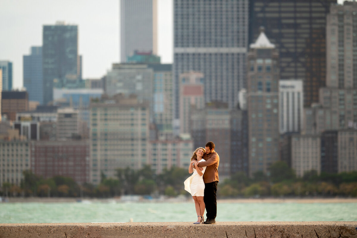 Engaged couple staying warm during windy engagement photoshoot in Chicago