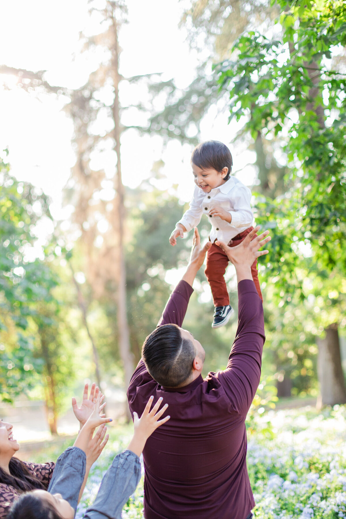 dad tosses laughing son in the air