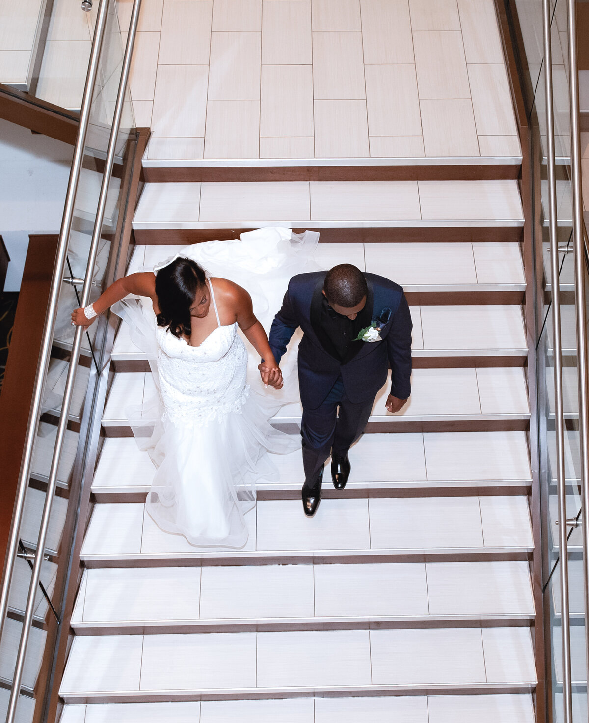 bride-and-groom-walking-staircase-modern-atlanta-venue