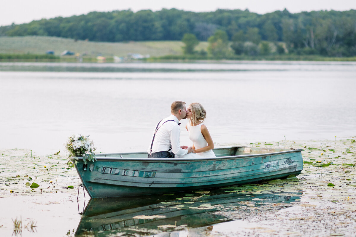 bride and groom kissing in the boat on detroit lake