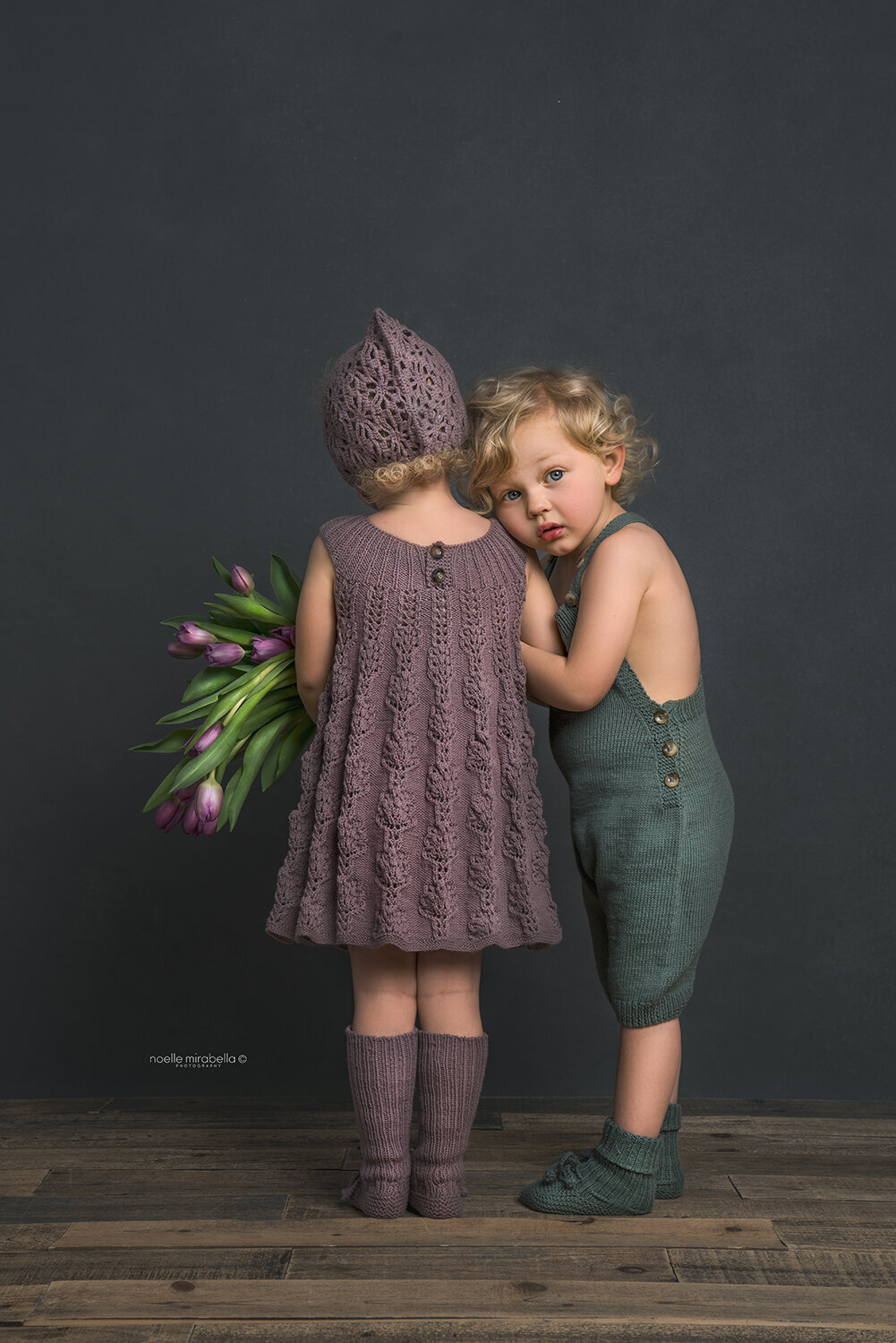 Children snuggles togther wearing handmade knits clothing.