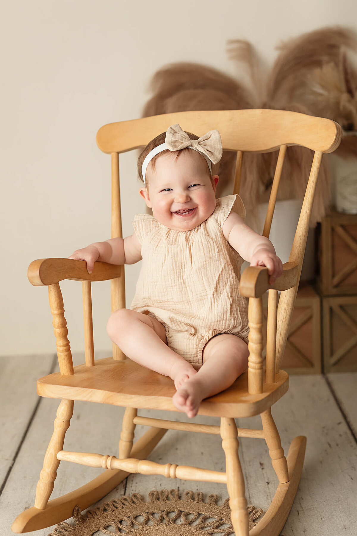 Cute baby girl smiling in a rocking chair.
