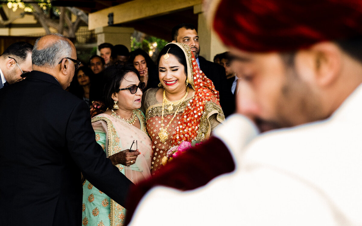 Bride and groom share an emotional wedding moment, captured in a timeless documentary style.