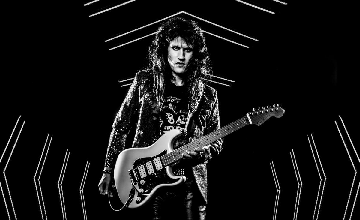 Male musician portrait black and white Rocky Kramer velvet suit jacket holding  white electric guitar large arrows surrounding