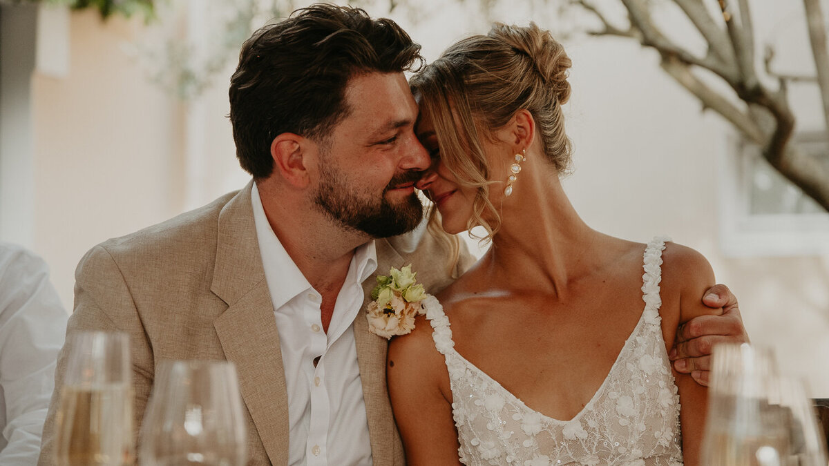 Bride and groom cuddle during their wedding speeches at Chateau Canet in Carcassonne. 