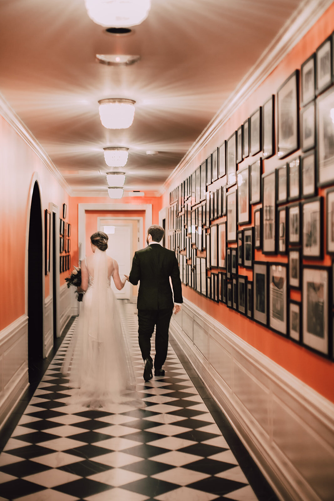 Bride and groom walk down hallway at Madison Club wedding