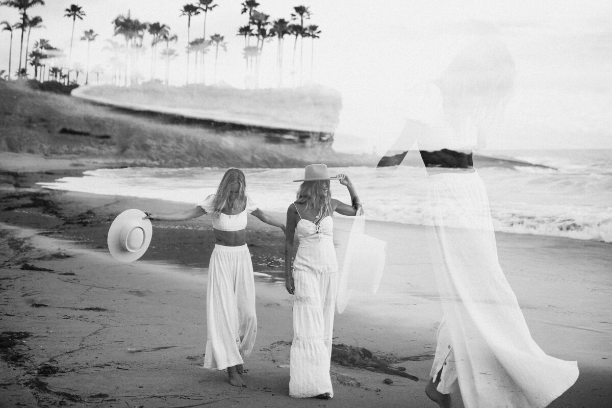 Women in white walking on beach for brand photography session