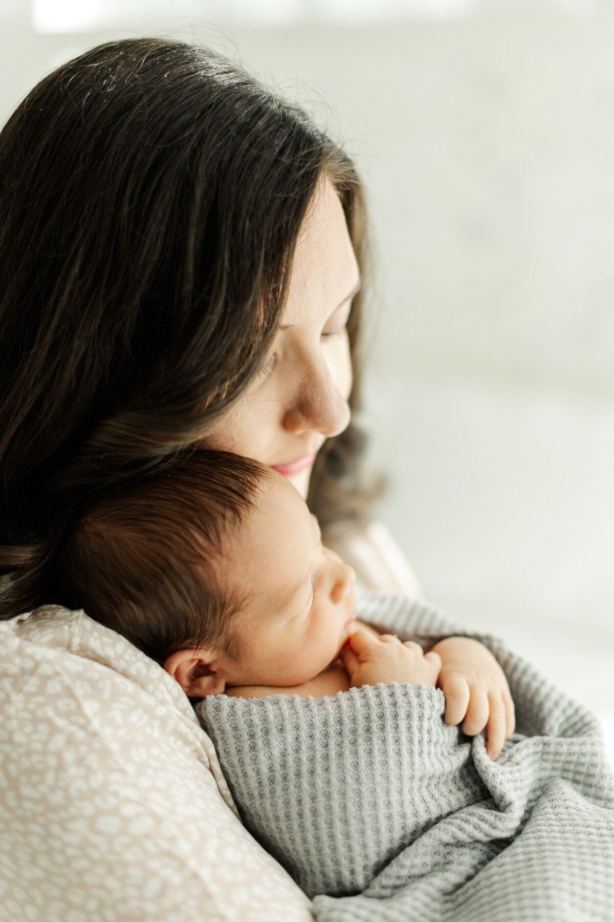 mom snuggles newborn baby boy for houston studio session