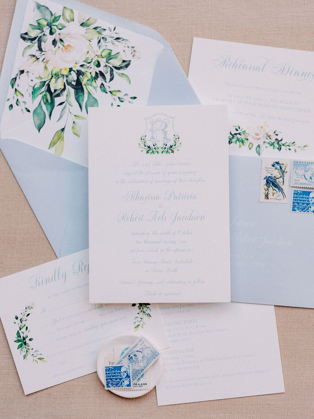 A beautifully designed wedding invitation suite with blue and white details, featuring elegant floral illustrations and vintage stamps. Perfect for luxury weddings.