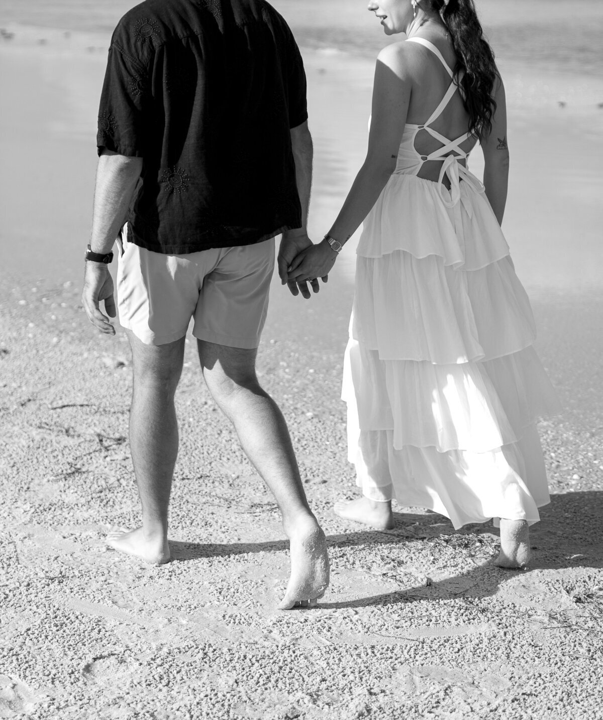 Couple walking on beach taken by film wedding photographers