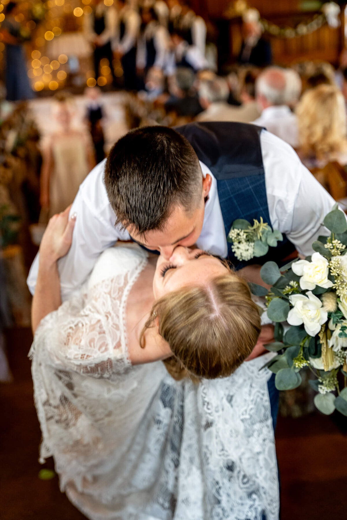 dramatic wedding photography depicting a bride and groom share a dip kiss during their exit from the ceremony location in Pittsburgh PA.
