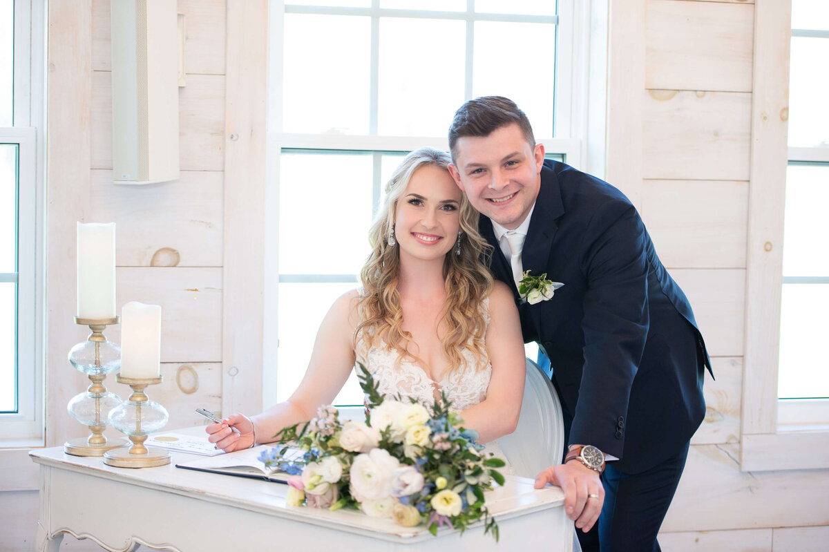 a photo of a bride and groom smiling at the camera just having signed their Ottawa wedding register