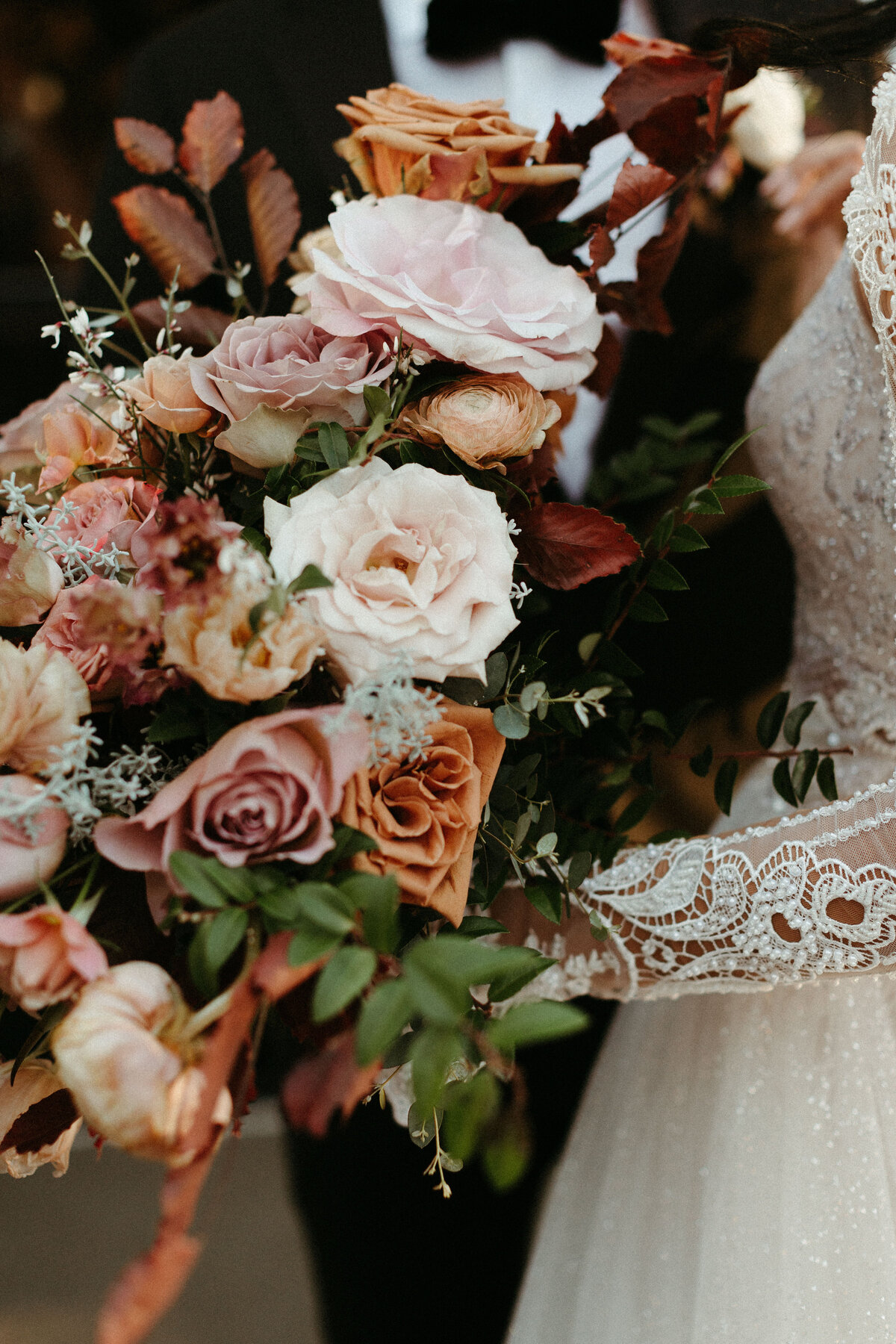 This elegant bridal bouquet brought hues of mauve, dusty pink, cream, burgundy, and terra cotta to this winter wedding. Lush with petal heavy roses, ranunculus, spray roses, copper beech, and greenery. Designed by Rosemary and Finch in Nashville, TN.