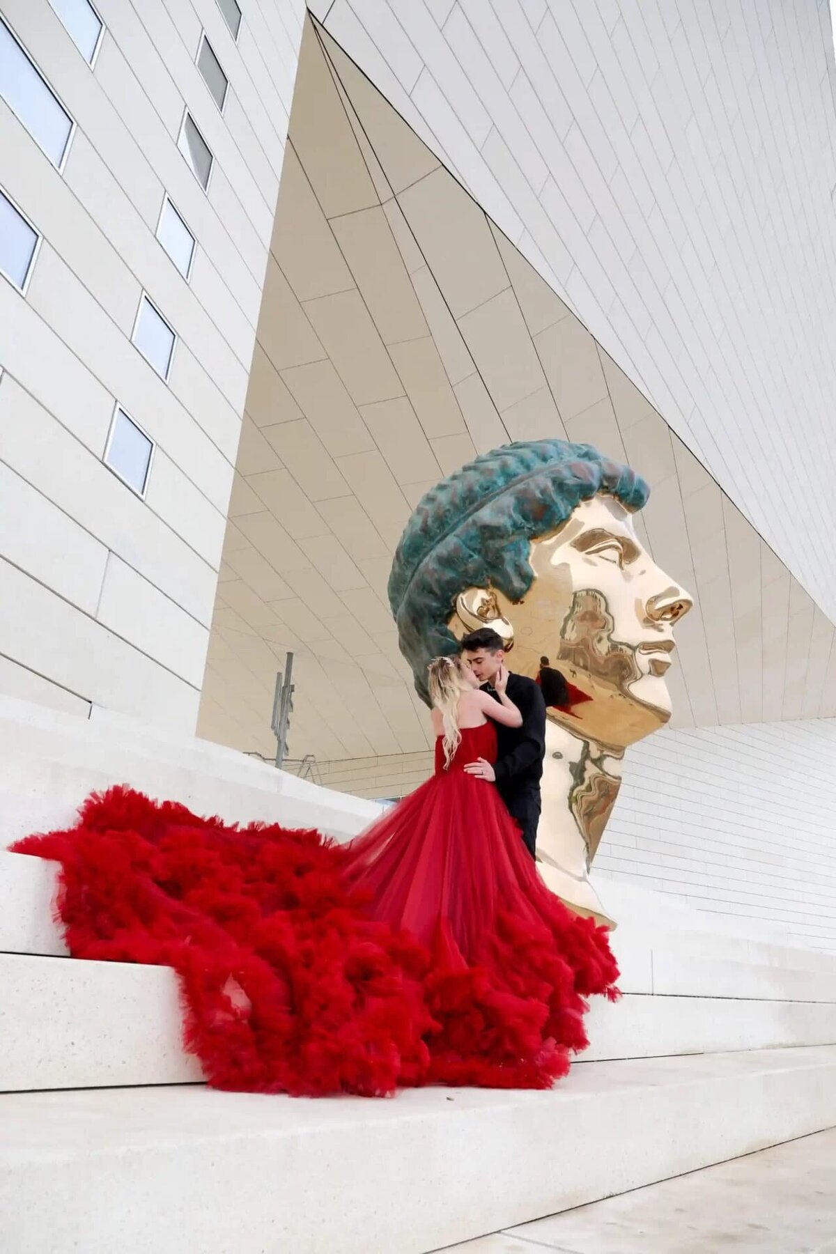 a couple having a photoshoot in paris with a red flying dress