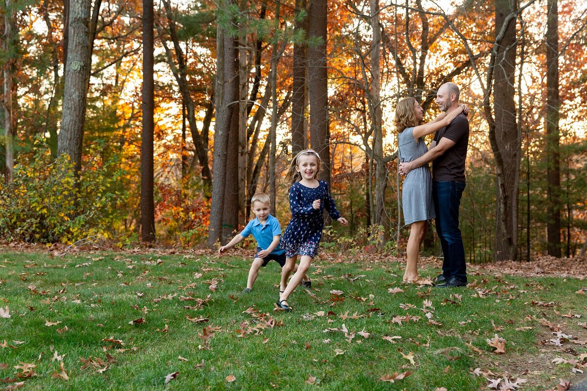 Children running around while parents are embracing