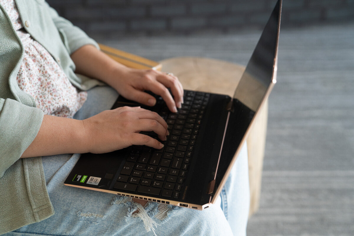 Emma Males Photographer Business Educator typing on a laptop as she works for small businesses marketing for photographers