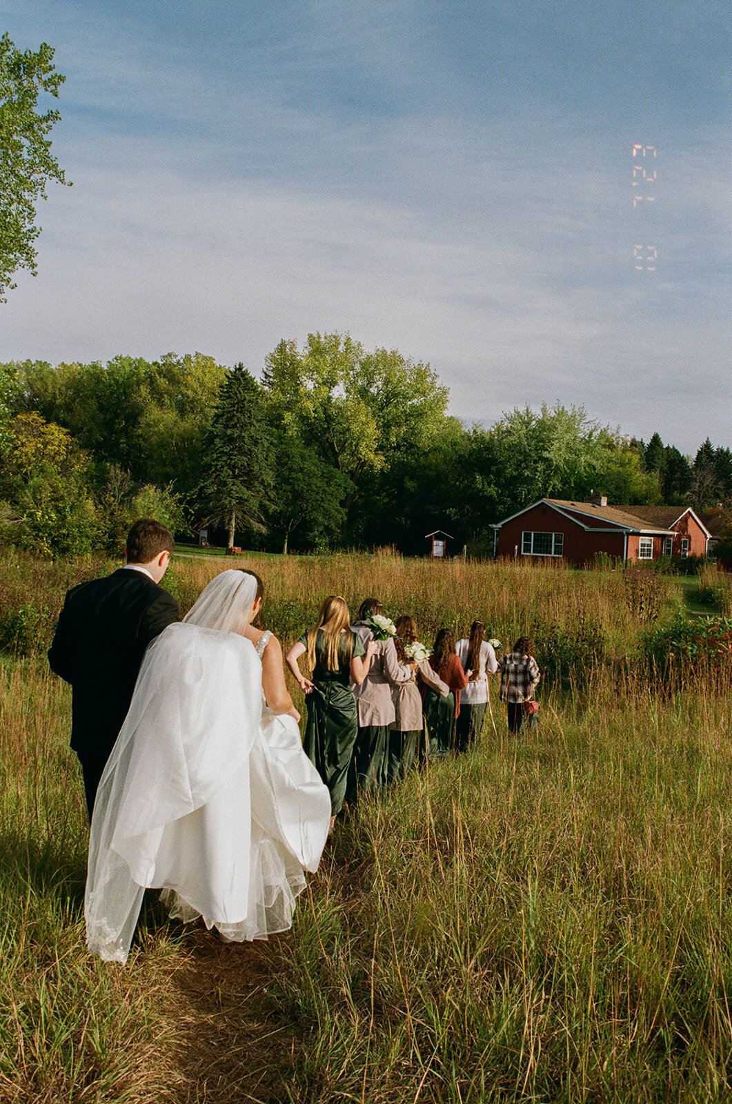 Bridal party casually walking away from camera on film.