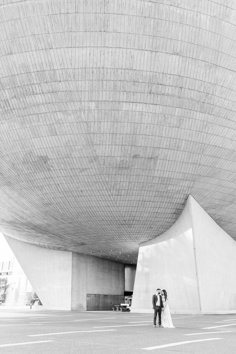 Black and white photo of couple posing for their engagement photos outside of The Egg in downtown Albany, NY