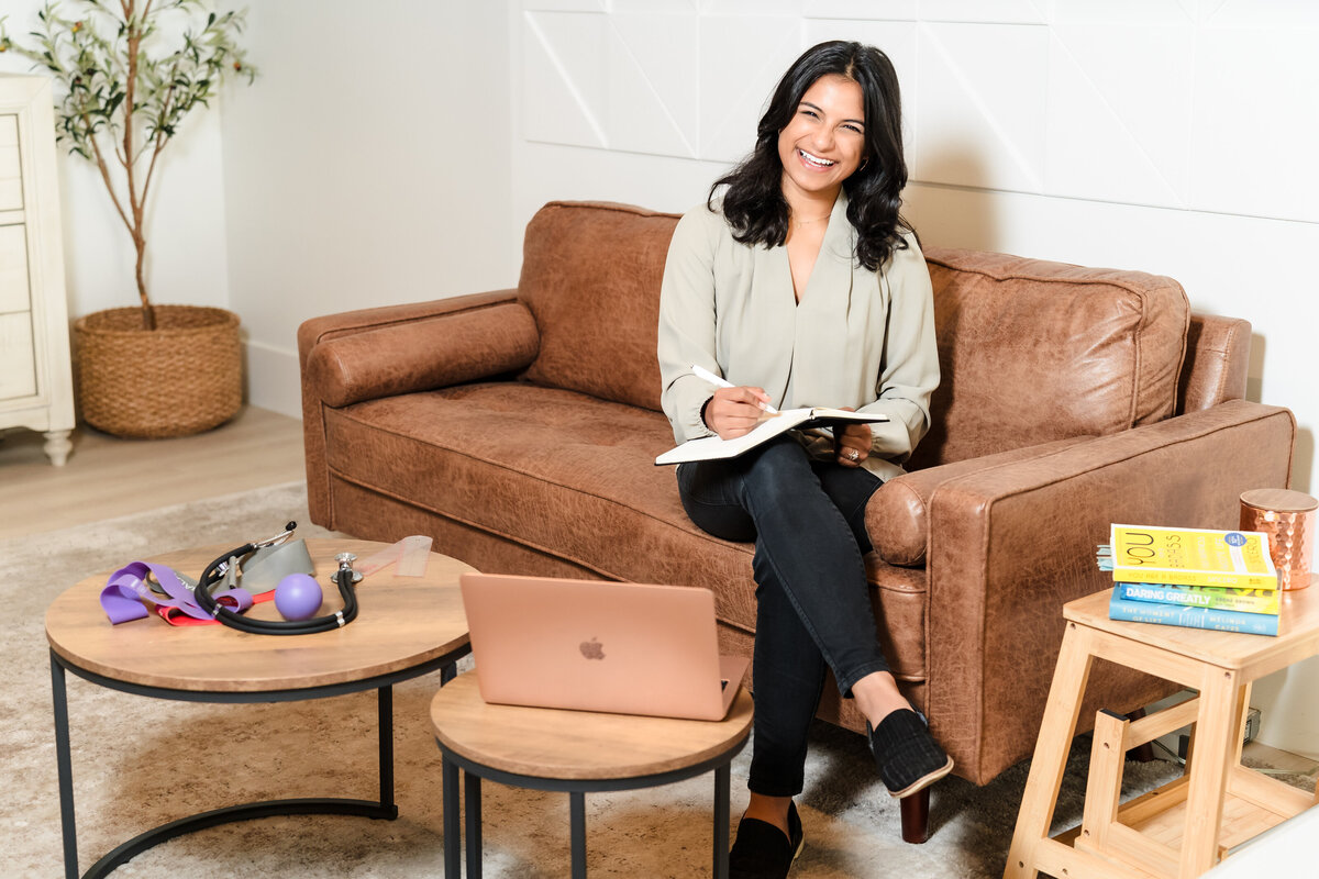 physical therapist posing sit with a notebook in her lap