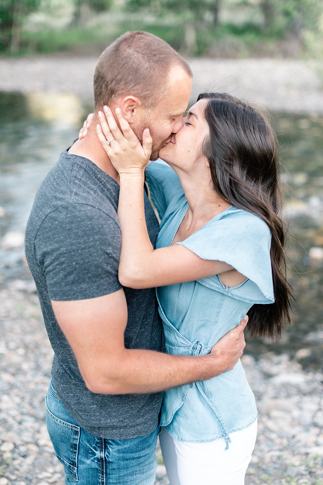 Couple kissing next to river at Sun Valley Engagement Session with the Best Sun Valley Wedding Photographers