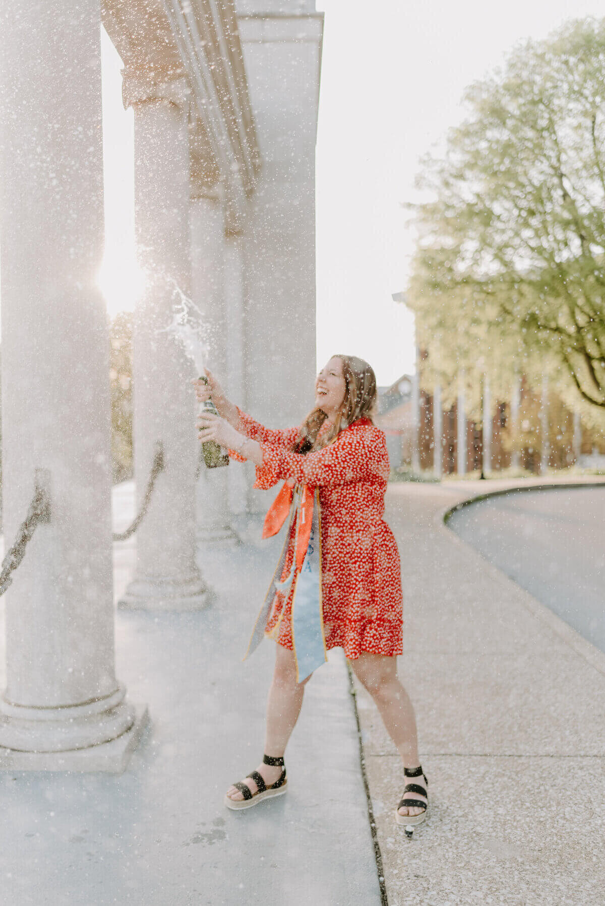 senior popping champagne by senior photographers in nashville tn