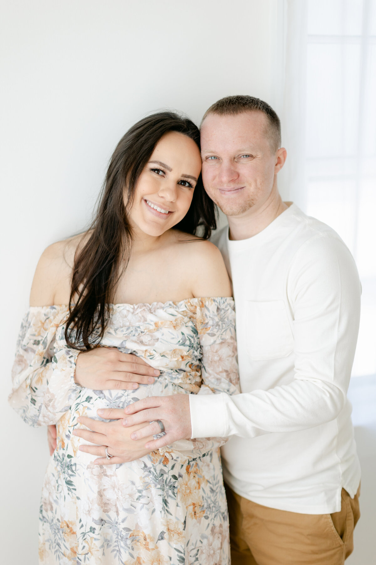 expecting parents in a brightly lit studio captured by Philadelphia Maternity Photographer
