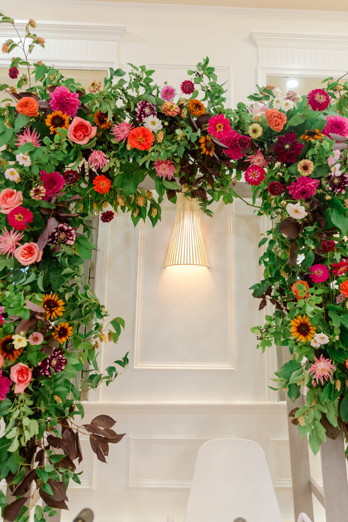 A large arch of colourful flowers and lush, hanging greenery at a Montreal wedding ceremony.  