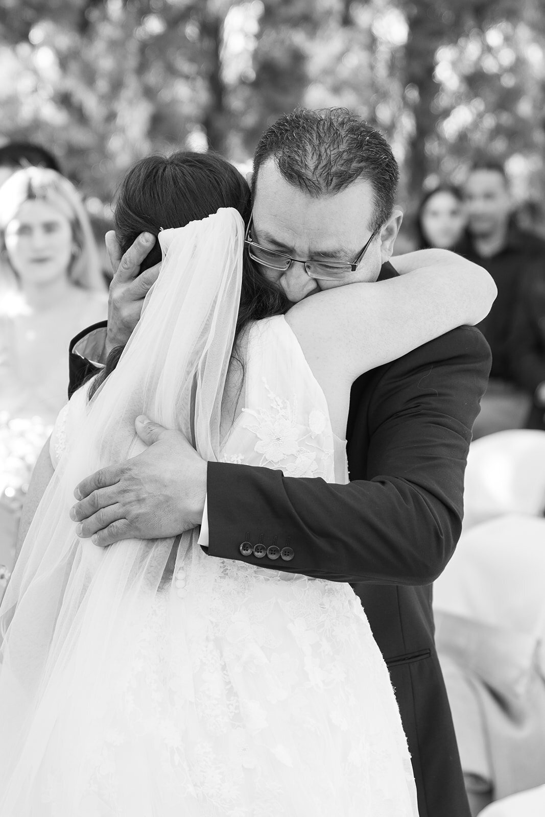 Father of the bride hugs his daughter during the Wolf Lakes Park wedding ceremony