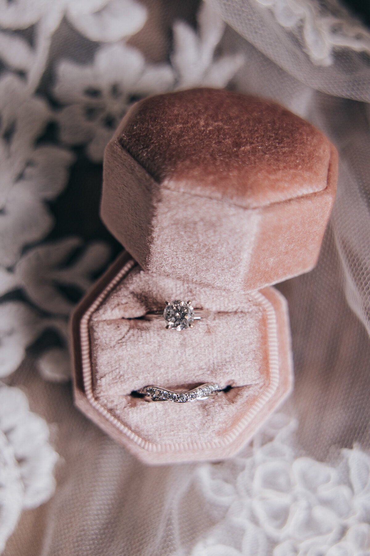 Detail shot of stunning diamond solitaire and diamond wedding band in pink velvet ring box photographed by Nova Markina