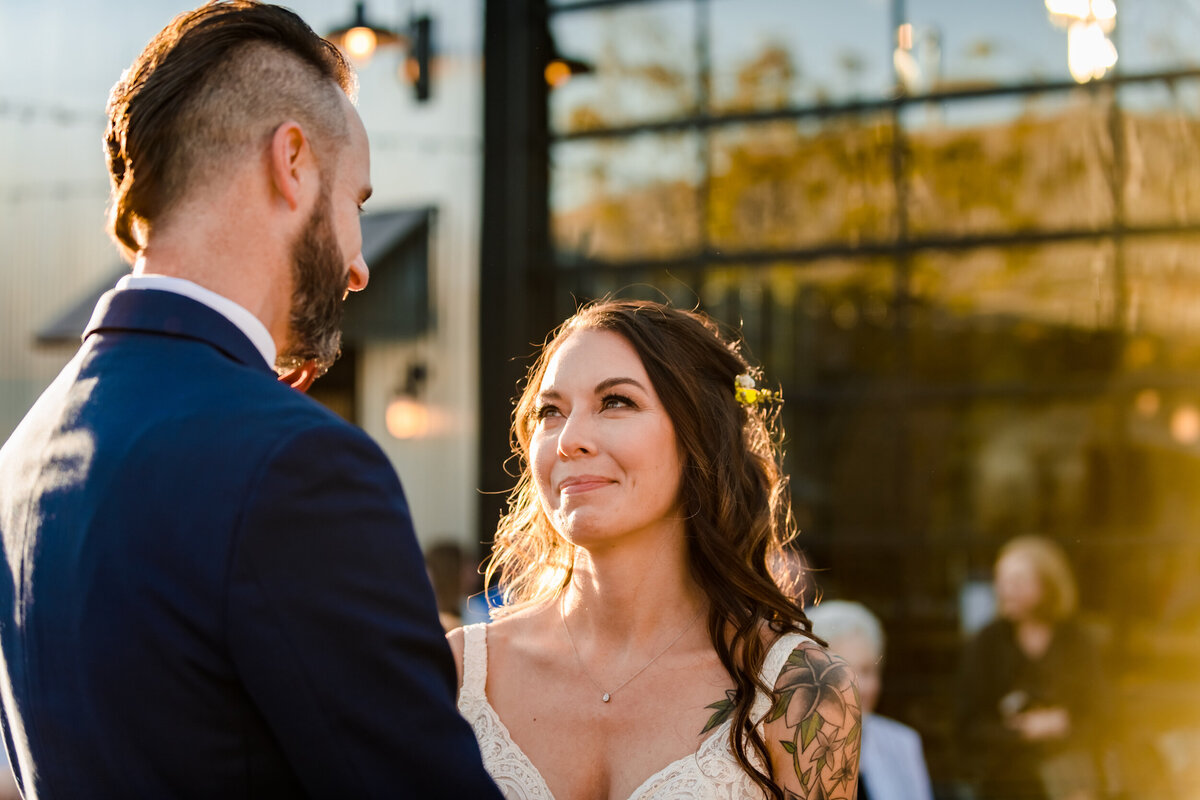 Bride looks at groom during wedding ceremony at Warehouse 109