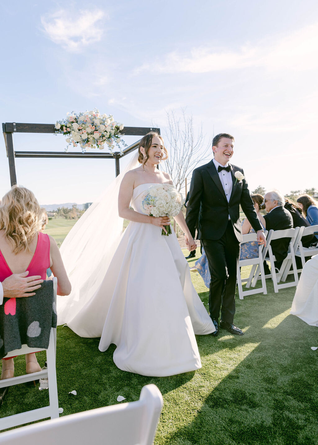Joyful bride and groom walking back up the aisle after wedding ceremony at Arizona Biltmore.