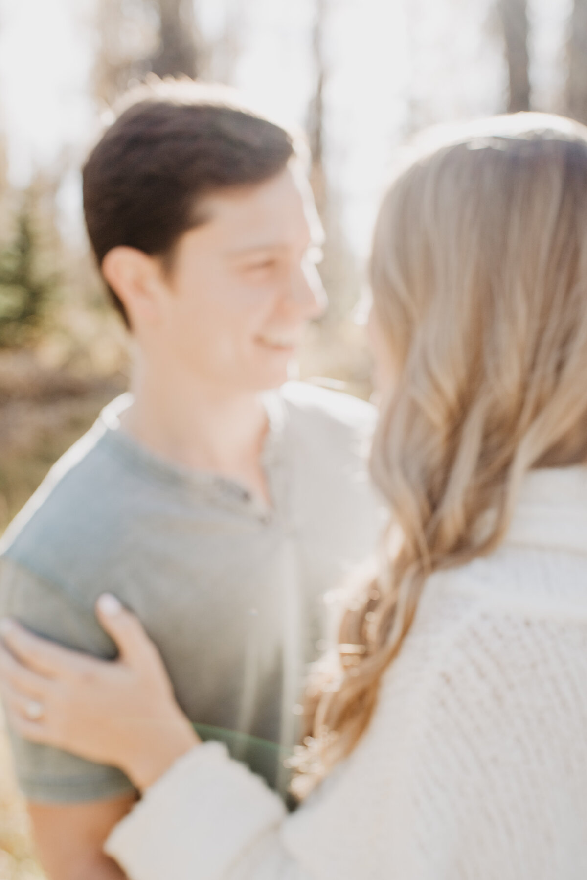 Photographers Jackson Hole capture couple hugging during golden hour portraits