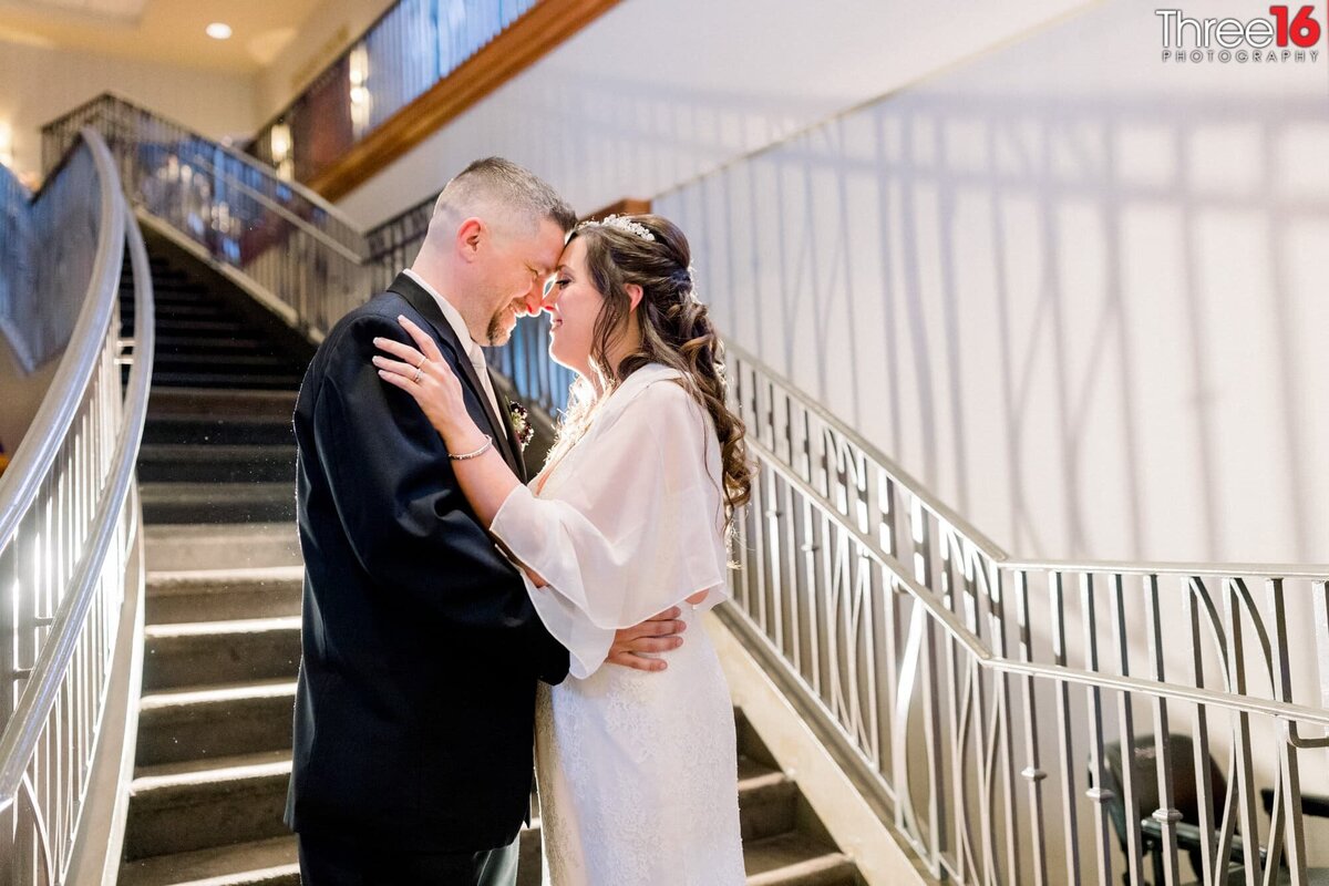 Tender moment with smiles of newly married couple on the staircase