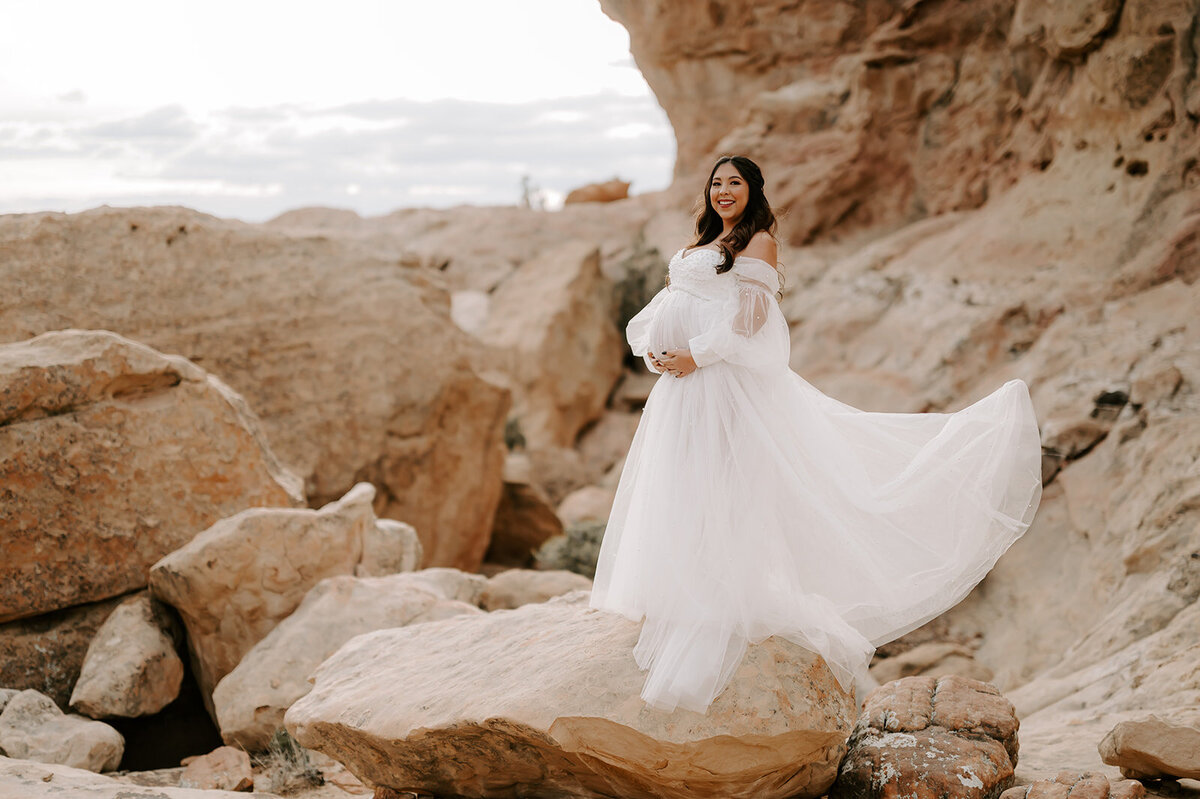 woman standing on cliff in white flowy dress
