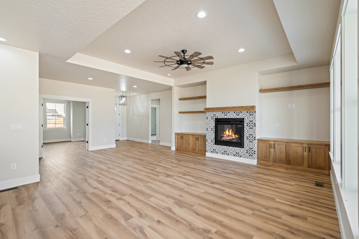 living room space with wooden floors fire place  and ceiling fan