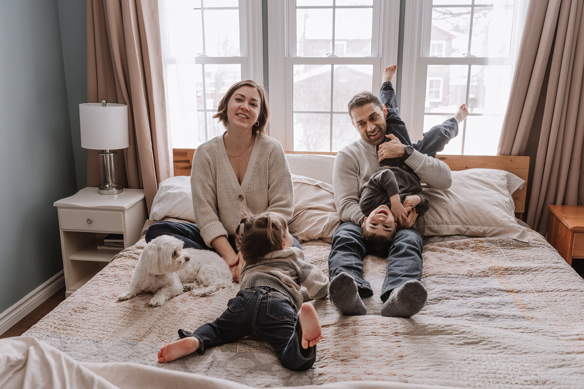 Family playing on bed