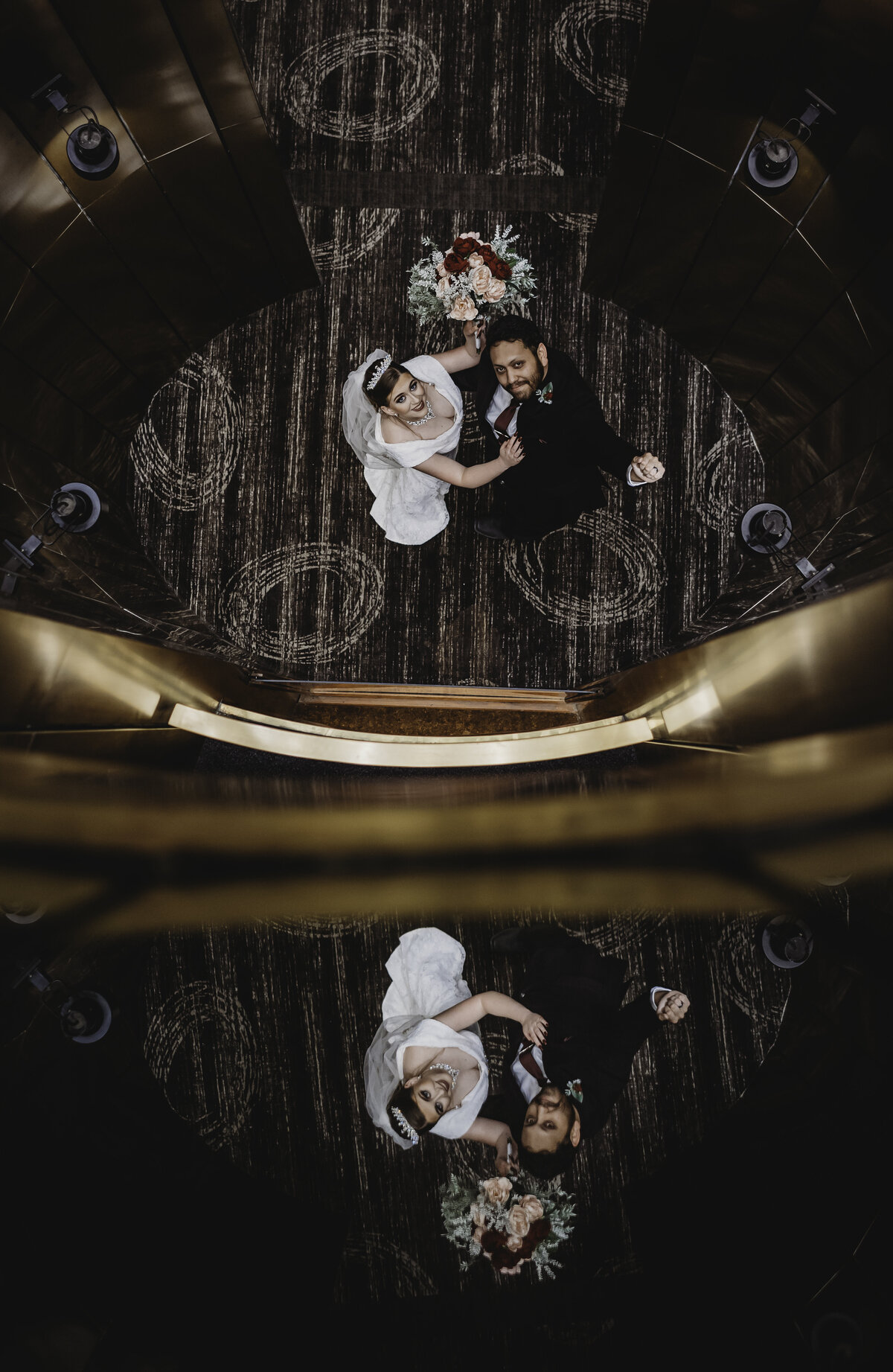 bride and groom looking in a mirror smiling