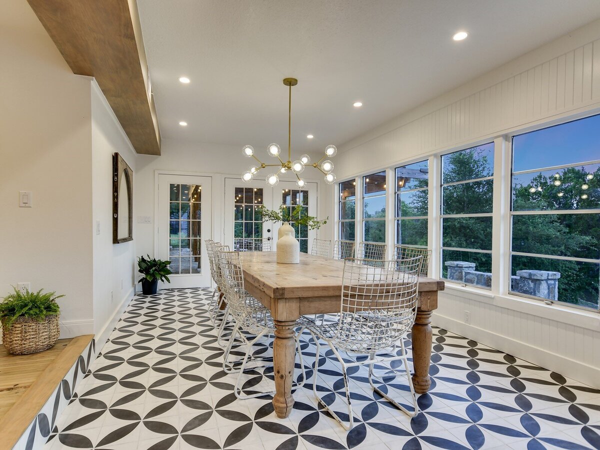 Sunroom dining area with decorative tile and large window