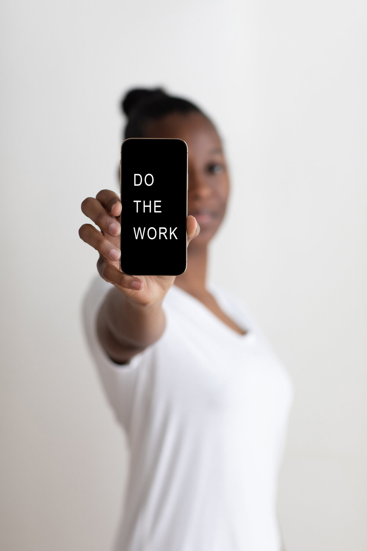 woman-holding-iphone-that-says-do-the-work
