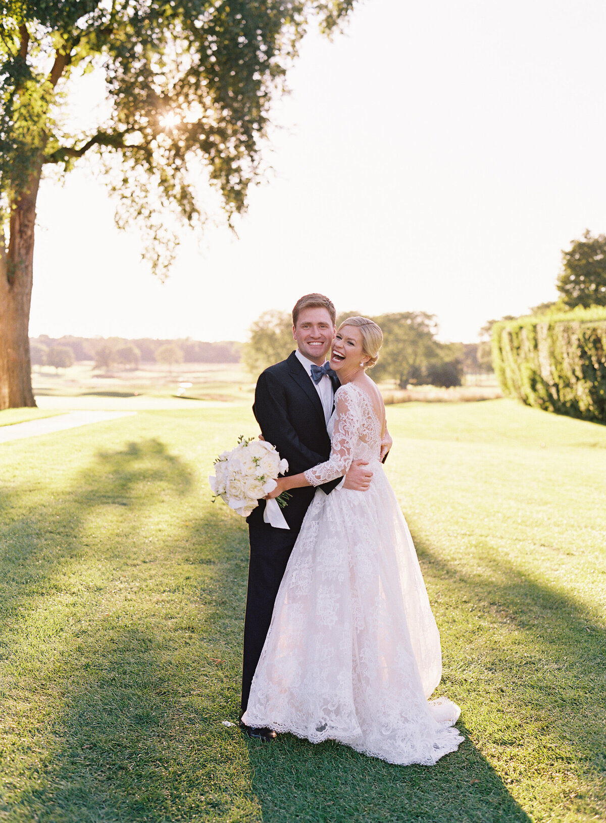 Bride and groom holding hands in front of the lake. 