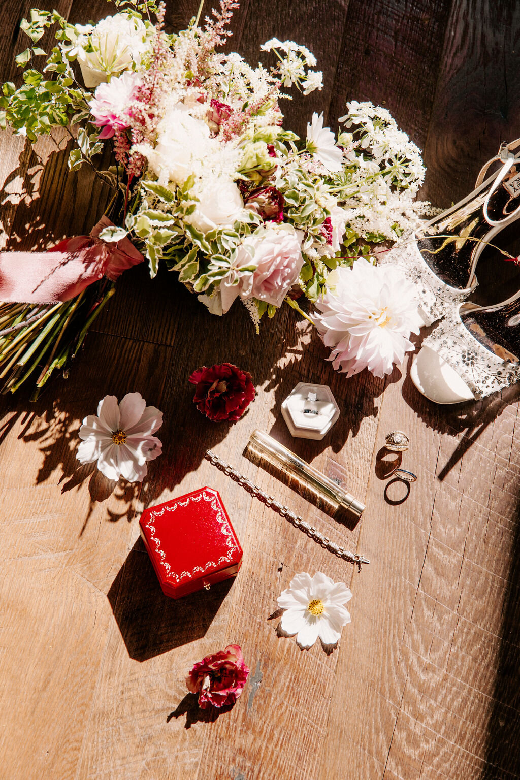 A bridal bouquet with shoes, rings, and perfume.
