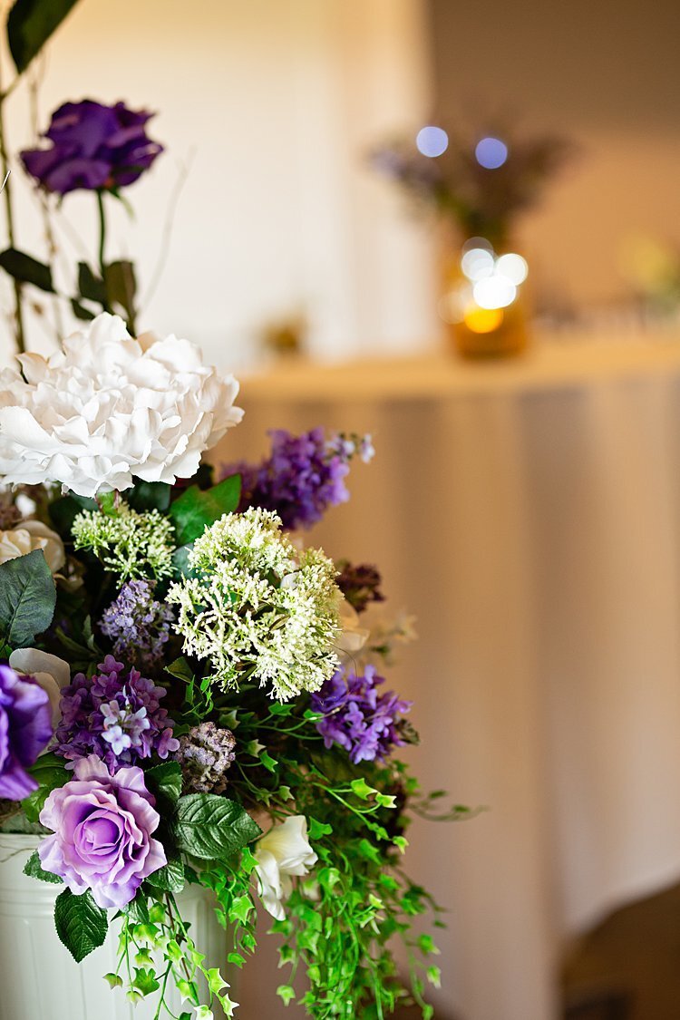 Purple, white and green floral arrangement at wedding reception