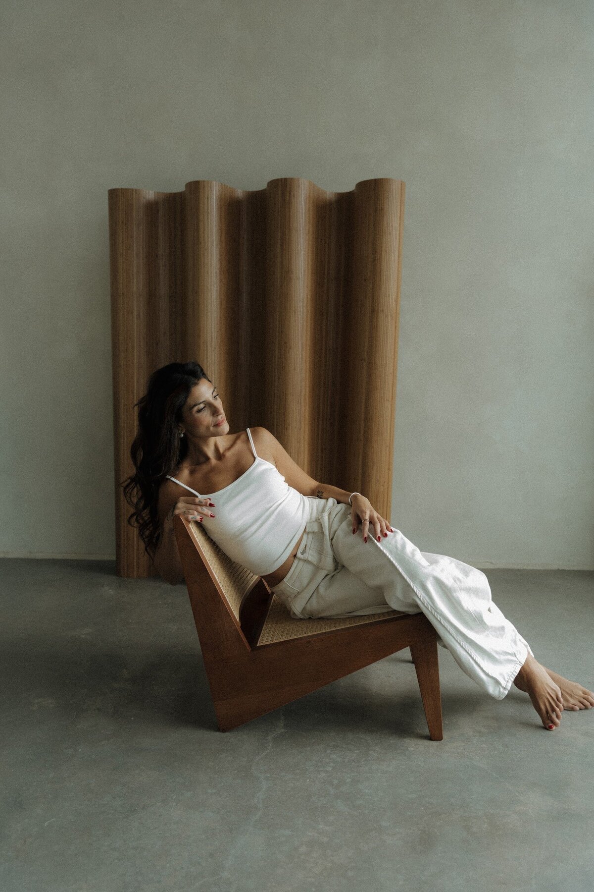Jiordana resting in a wooden lounge chair