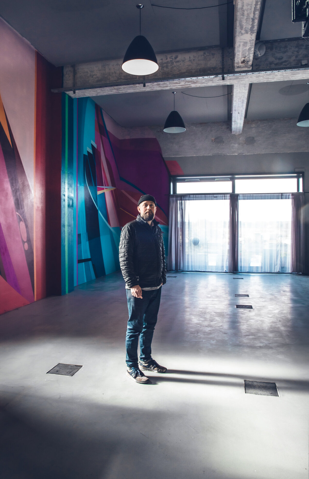 Artist Henrick Hansen in front his mural at AMASS