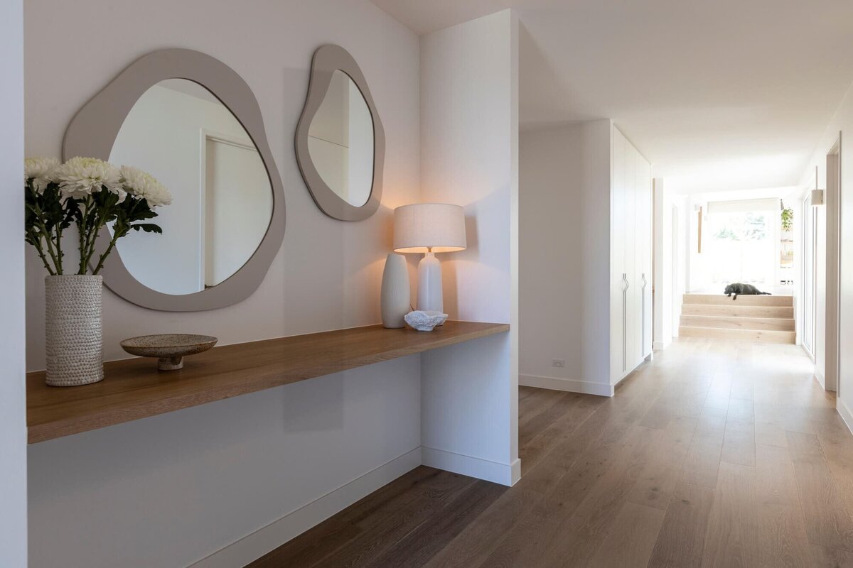 Hallway with irregular shaped mirrors and hallway table