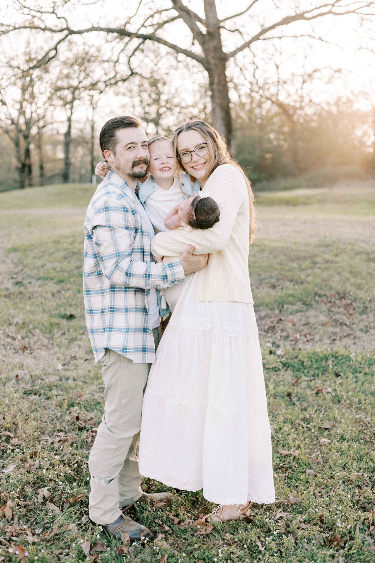 family hugging baby during outdoor peoria illinois newborn photos 