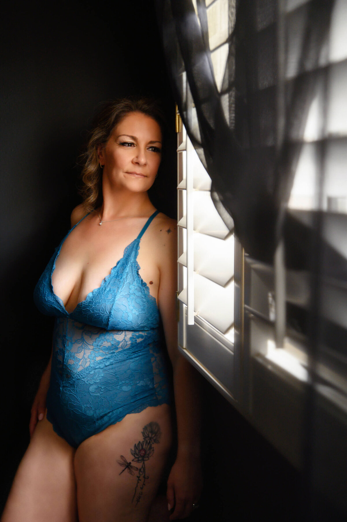 Lady smiling looking out the window for her Toronto boudoir photography session
