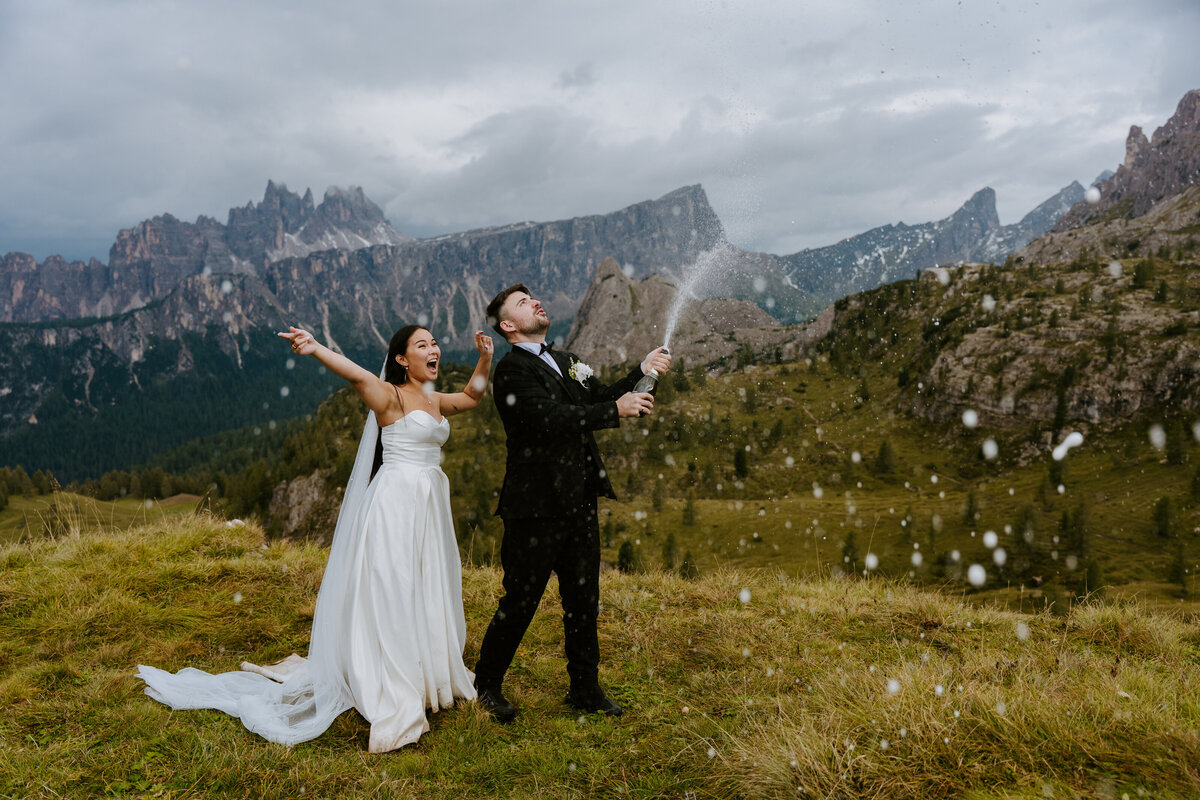 Bride and groom popping champagne in the Dolomites.