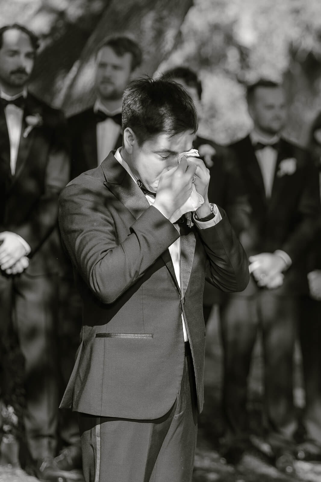 emotional photo of a groom crying as his bride walks down the aisle